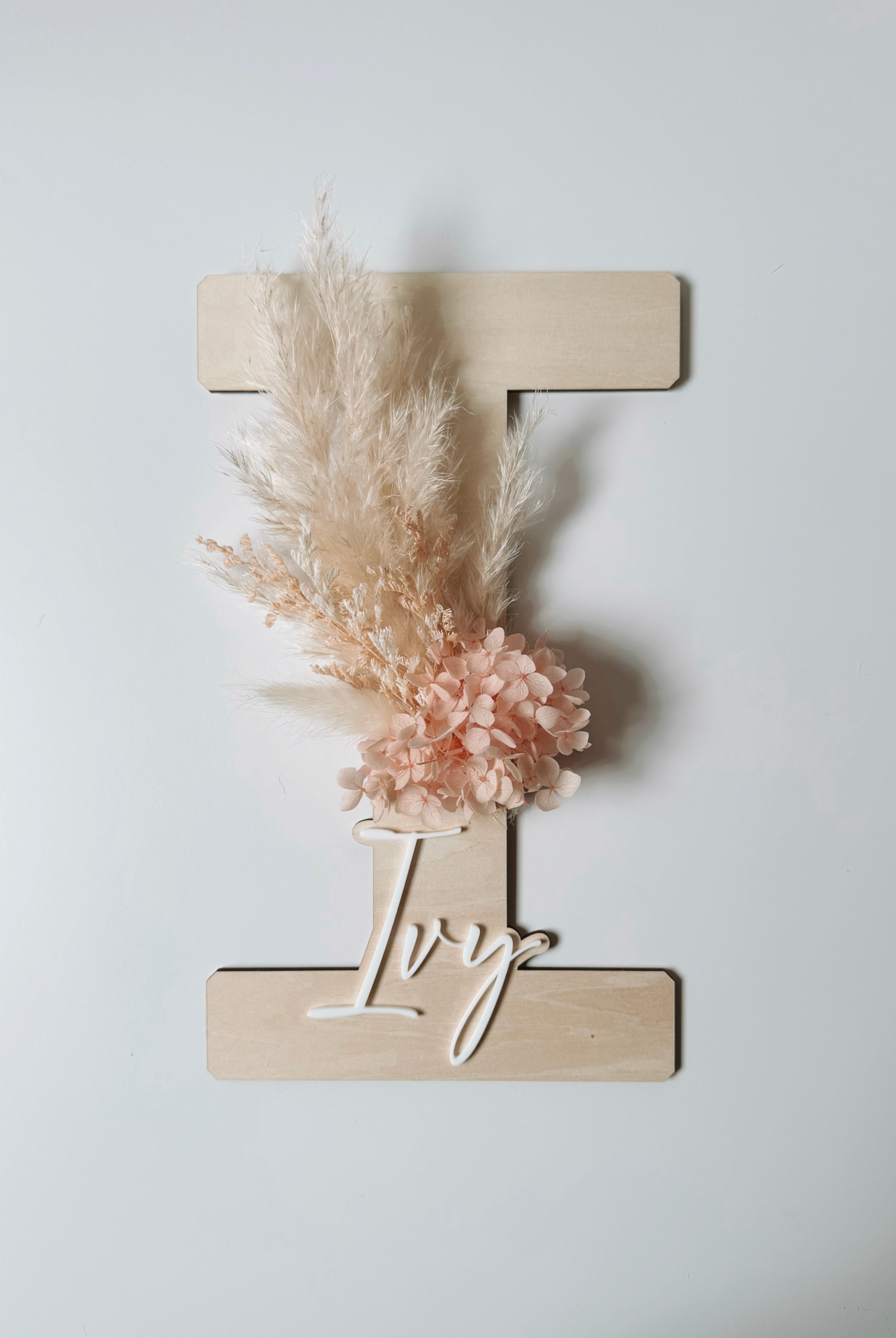 Dried floral wooden plaque with acrylic and/or laser engraved text or name, letter/initial, with dried preserved flowers tied to the plaque. Perfect for baby birth announcements or personalised gifts or keepsakes.