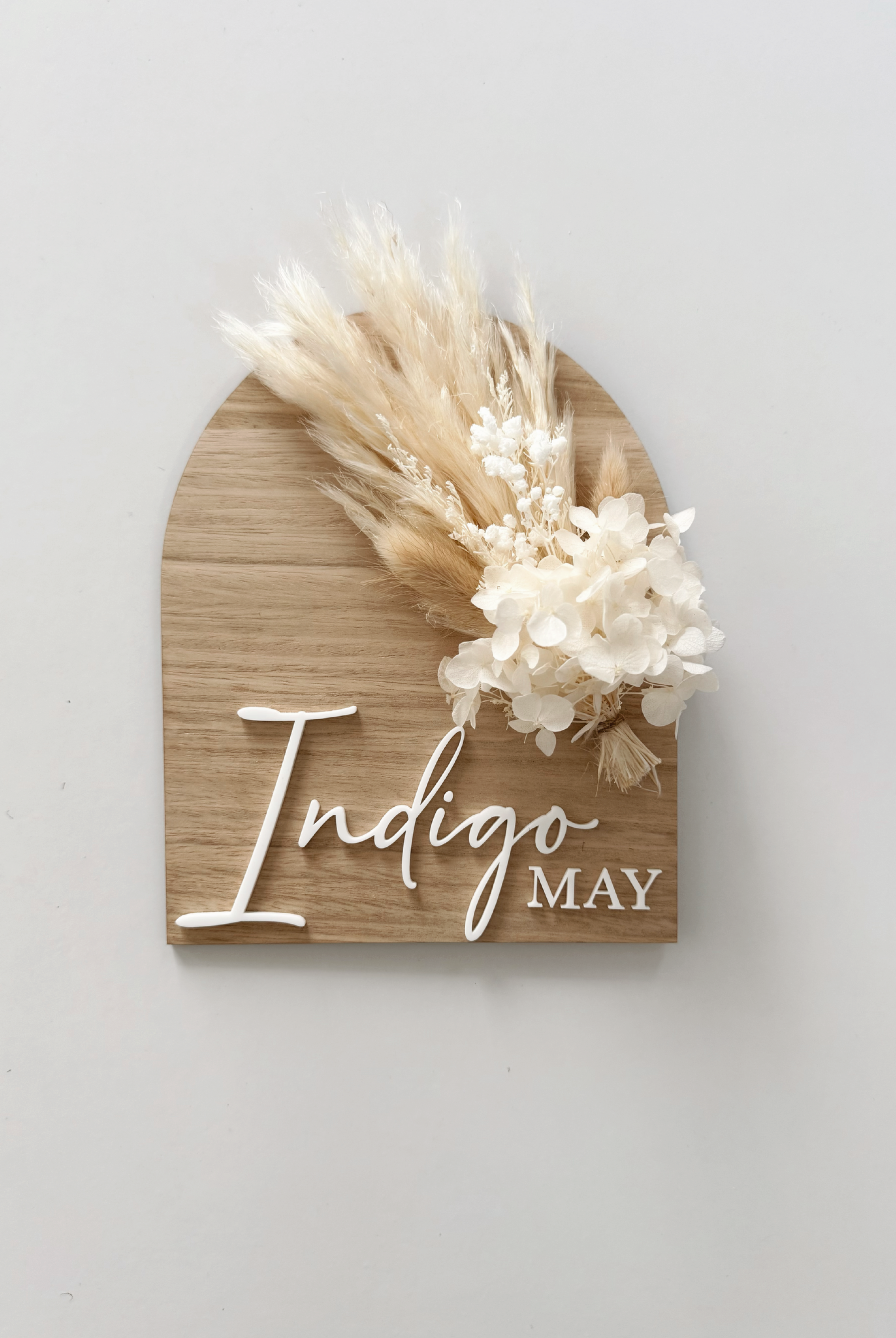 Dried floral wooden plaque with acrylic and/or laser engraved text or name, either arch or round shape, with dried preserved flowers tied to the plaque. Perfect for baby birth announcements or personalised gifts or keepsakes.