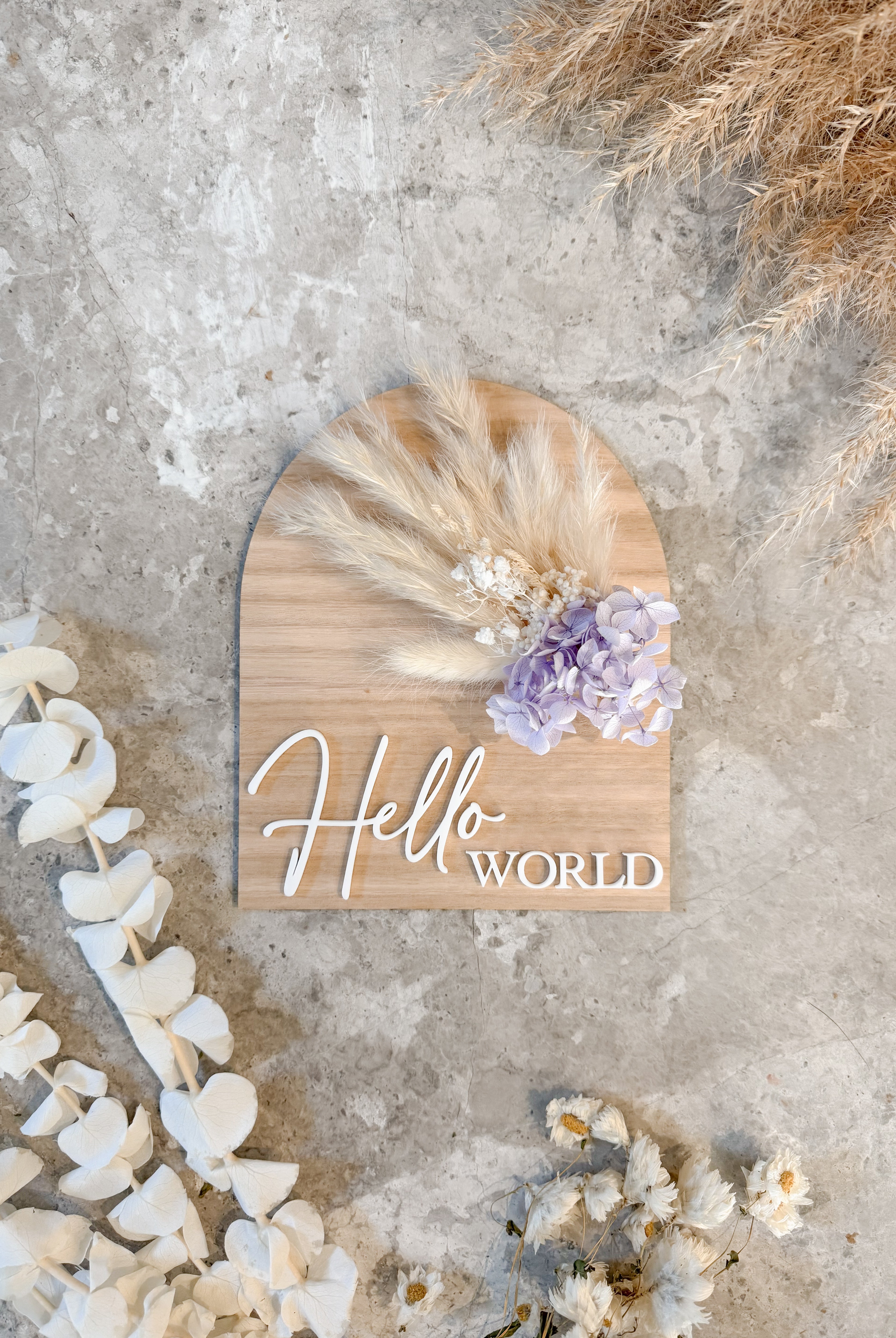 Dried floral wooden plaque with acrylic and/or laser engraved text or name, either arch or round shape, with dried preserved flowers tied to the plaque. Perfect for baby birth announcements or personalised gifts or keepsakes.
