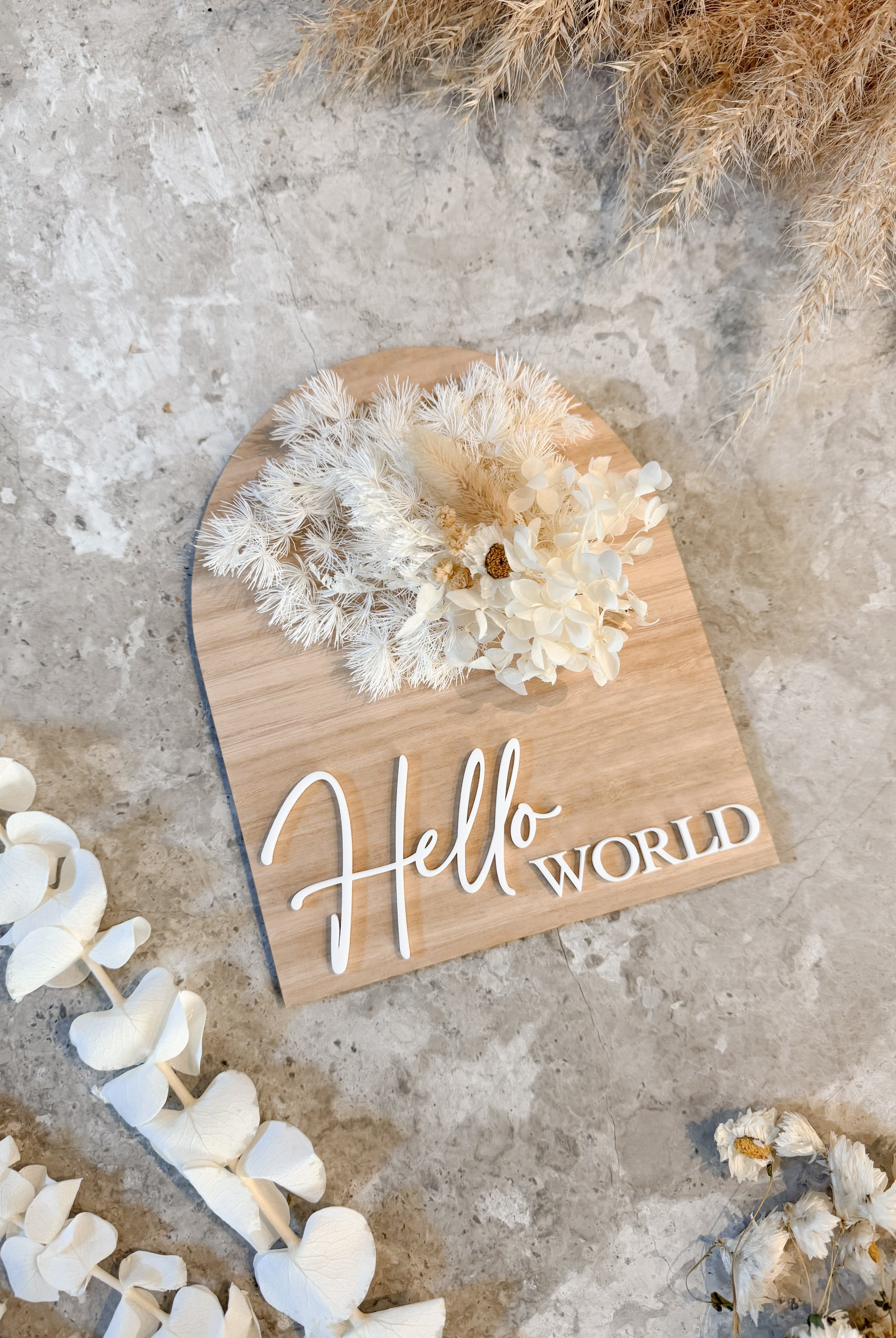 Dried floral wooden plaque with acrylic and/or laser engraved text or name, either arch or round shape, with dried preserved flowers tied to the plaque. Perfect for baby birth announcements or personalised gifts or keepsakes.