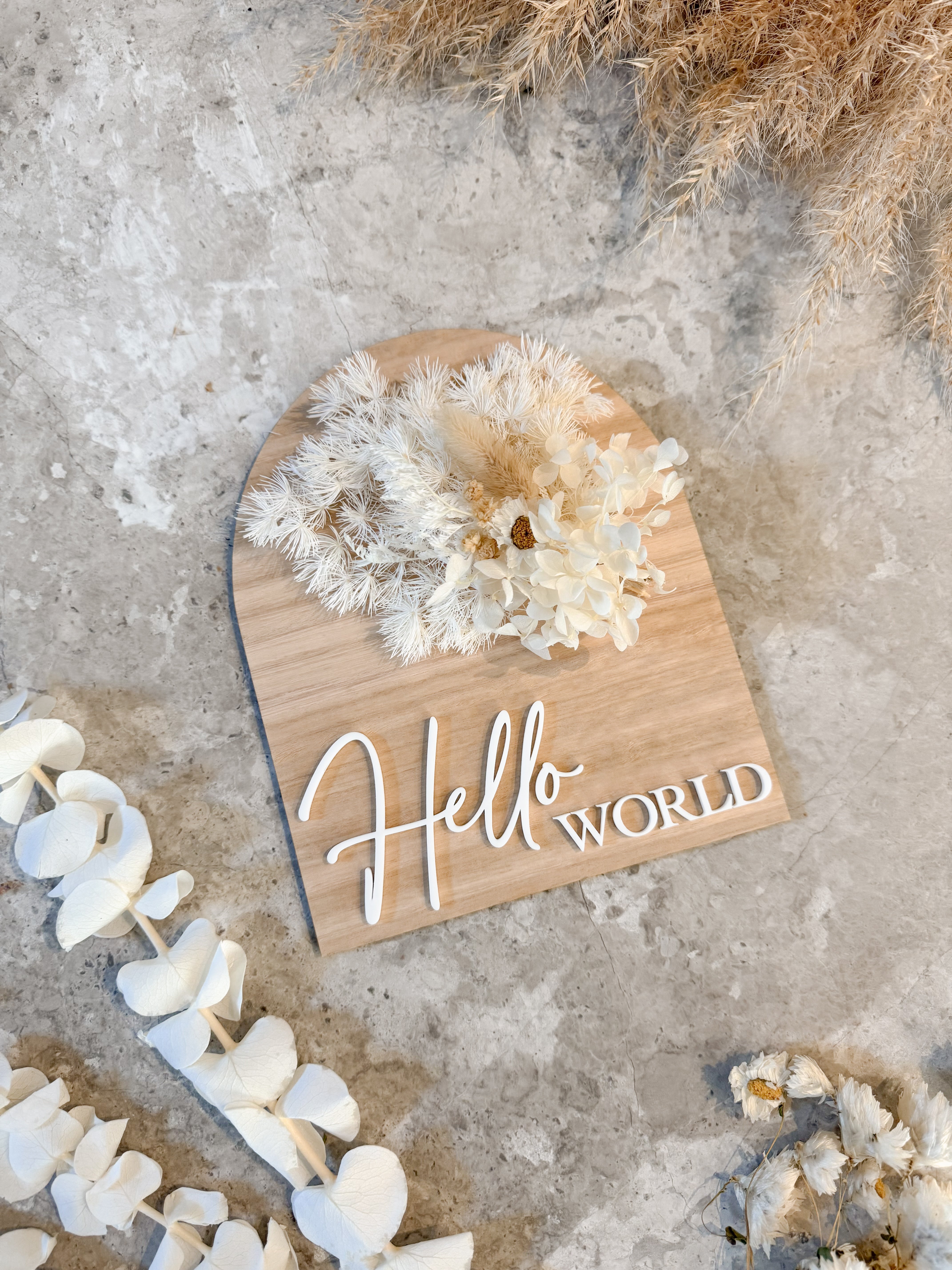 Dried floral wooden plaque with acrylic and/or laser engraved text or name, either arch or round shape, with dried preserved flowers tied to the plaque. Perfect for baby birth announcements or personalised gifts or keepsakes.