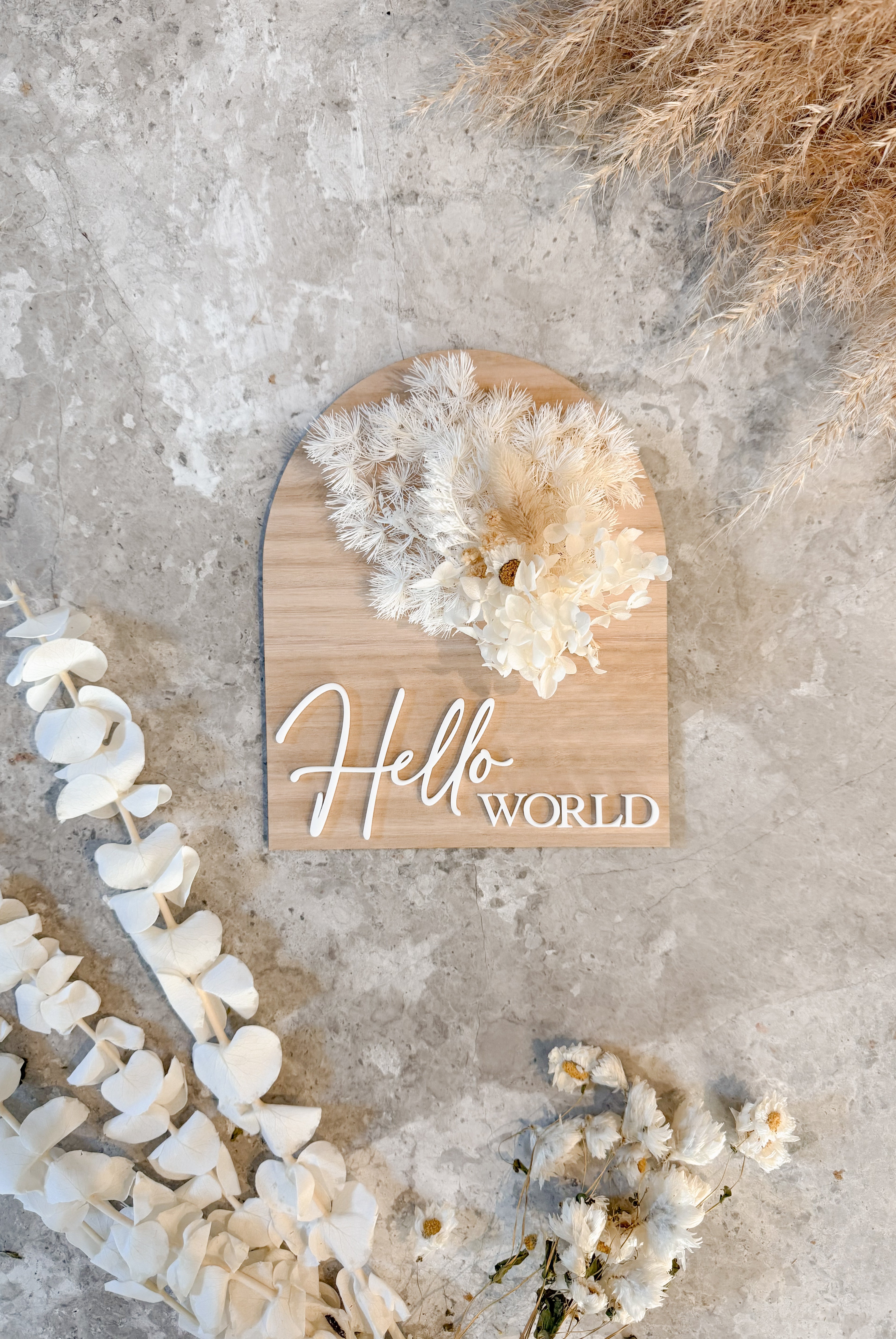 Dried floral wooden plaque with acrylic and/or laser engraved text or name, either arch or round shape, with dried preserved flowers tied to the plaque. Perfect for baby birth announcements or personalised gifts or keepsakes.