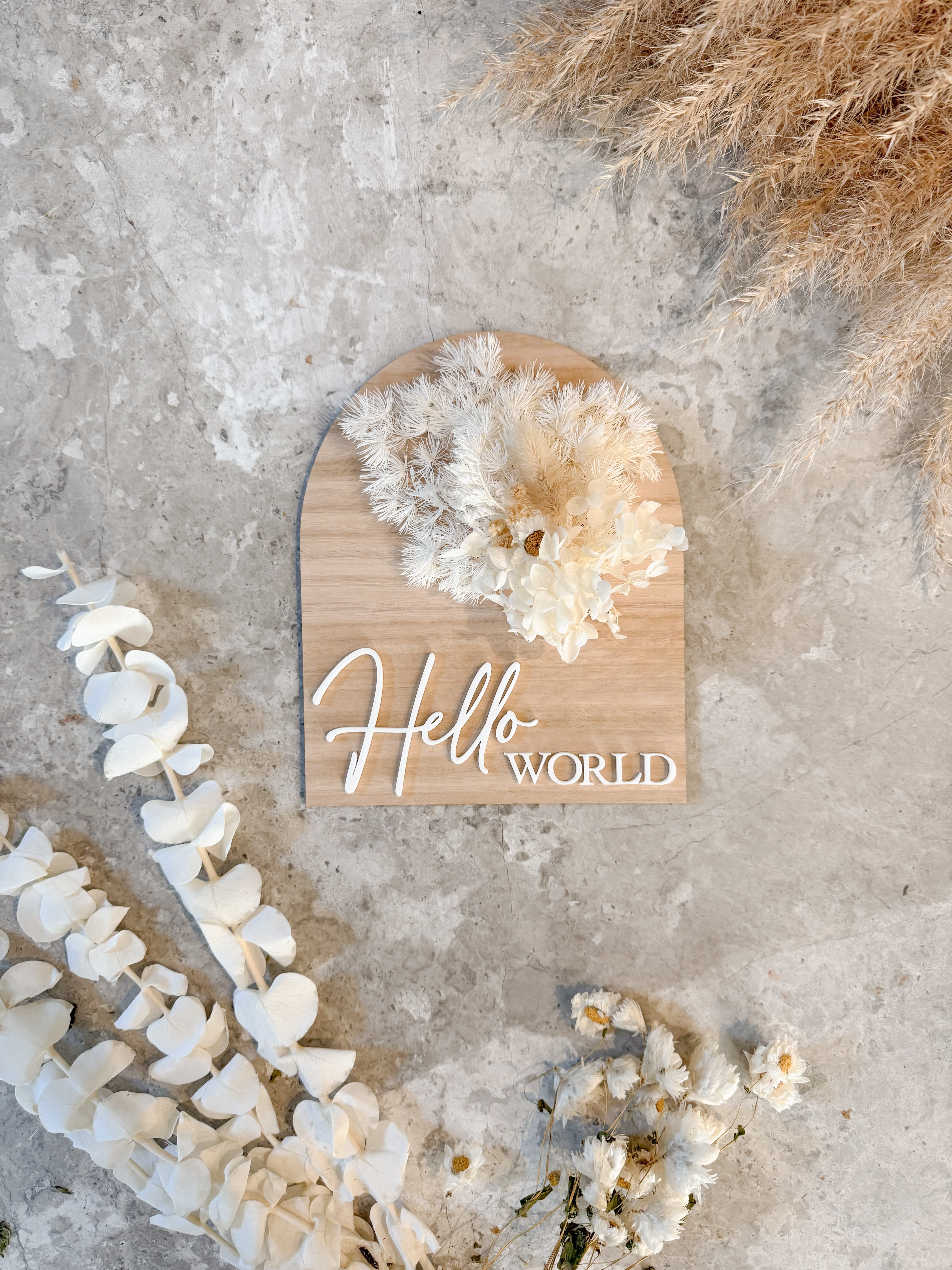 Dried floral wooden plaque with acrylic and/or laser engraved text or name, either arch or round shape, with dried preserved flowers tied to the plaque. Perfect for baby birth announcements or personalised gifts or keepsakes.