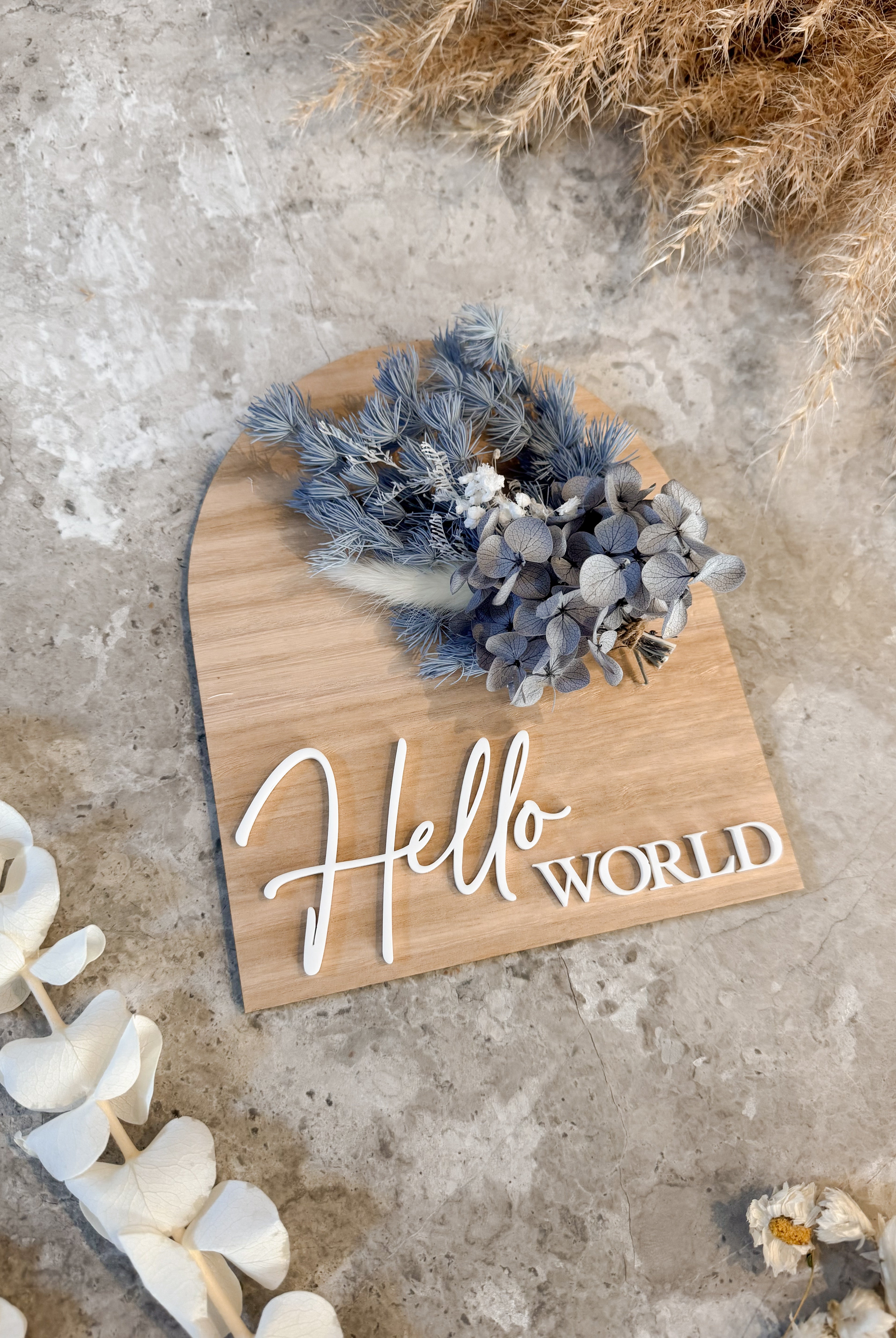 Dried floral wooden plaque with acrylic and/or laser engraved text or name, either arch or round shape, with dried preserved flowers tied to the plaque. Perfect for baby birth announcements or personalised gifts or keepsakes.