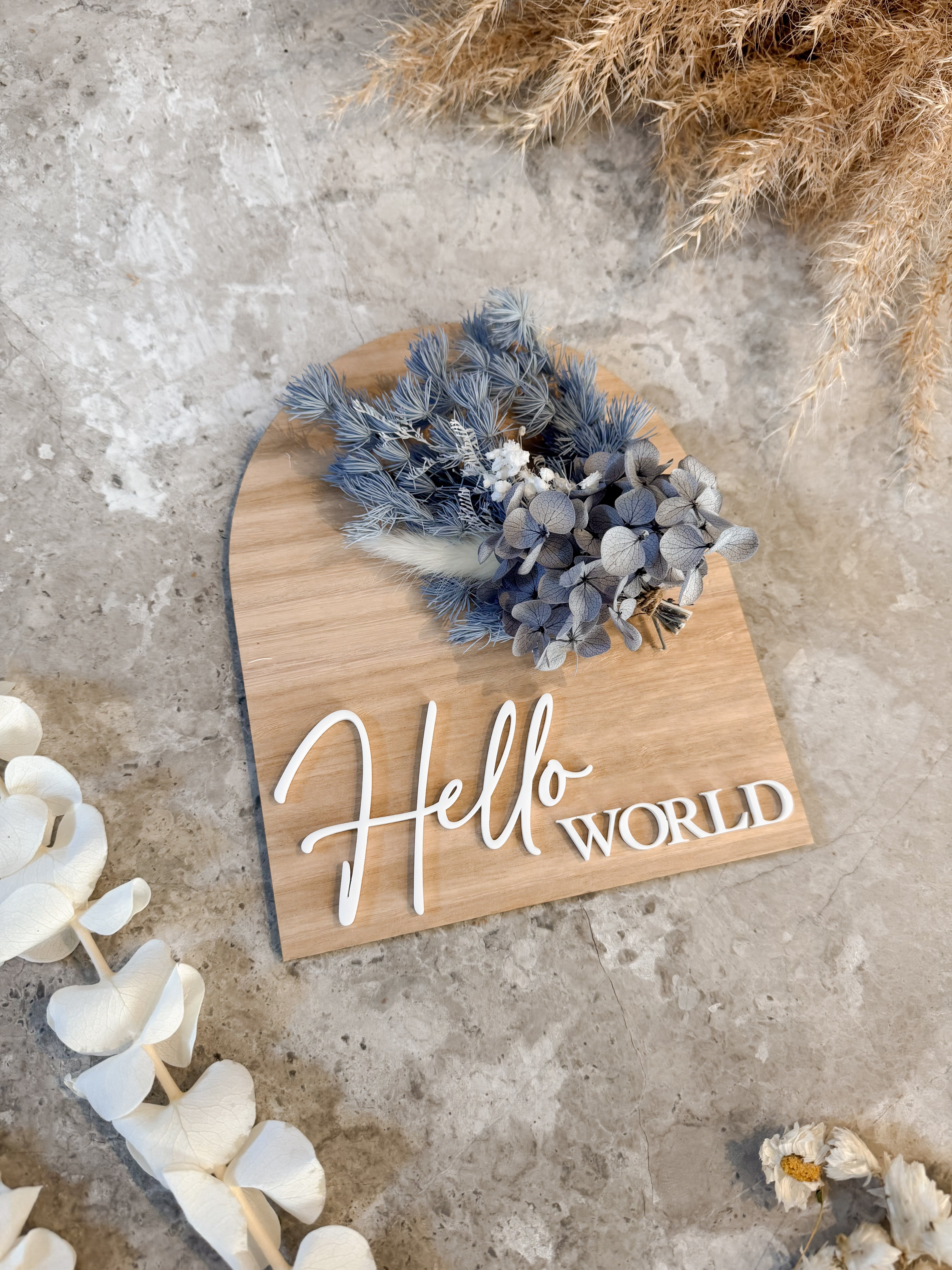 Dried floral wooden plaque with acrylic and/or laser engraved text or name, either arch or round shape, with dried preserved flowers tied to the plaque. Perfect for baby birth announcements or personalised gifts or keepsakes.