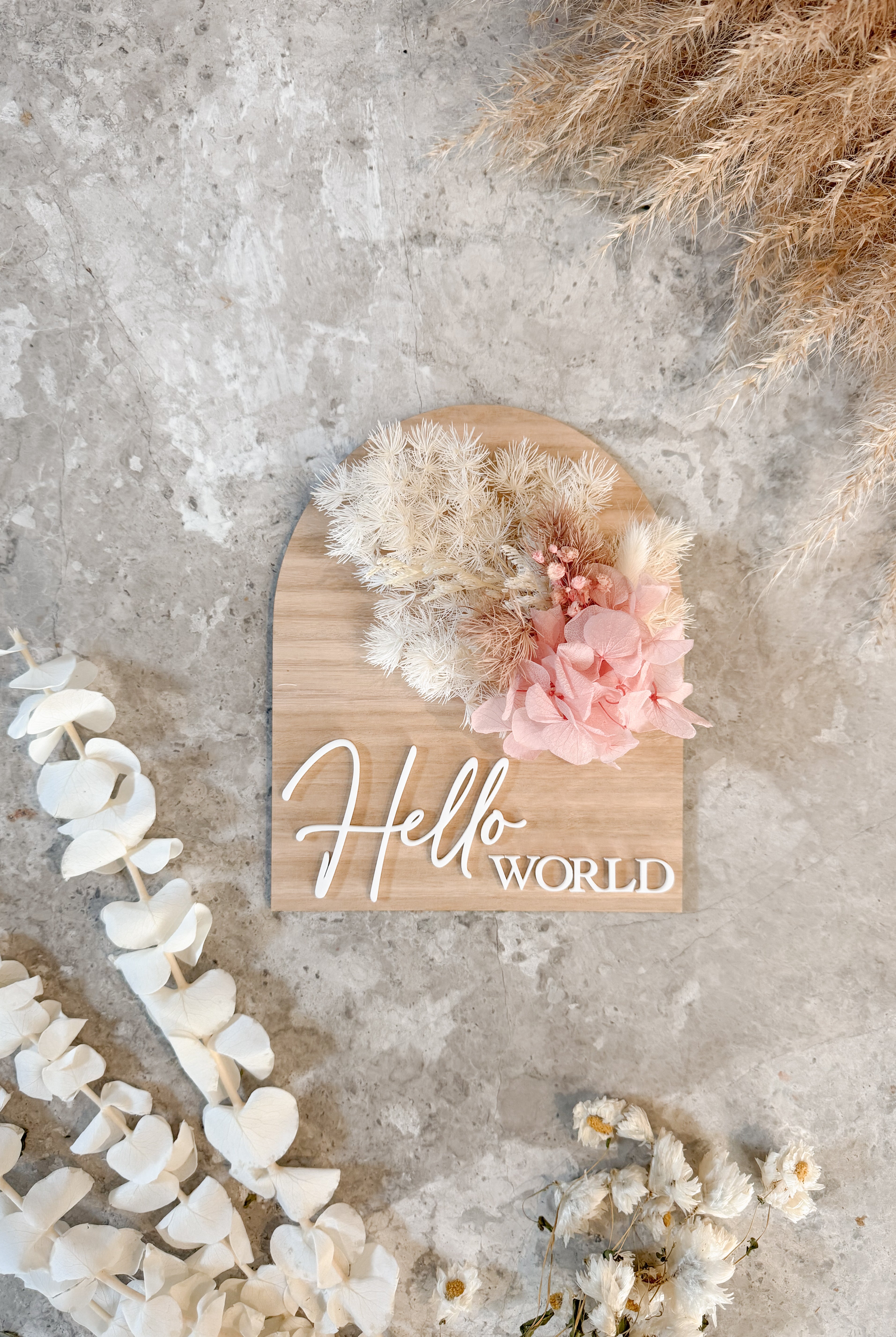 Dried floral wooden plaque with acrylic and/or laser engraved text or name, either arch or round shape, with dried preserved flowers tied to the plaque. Perfect for baby birth announcements or personalised gifts or keepsakes.