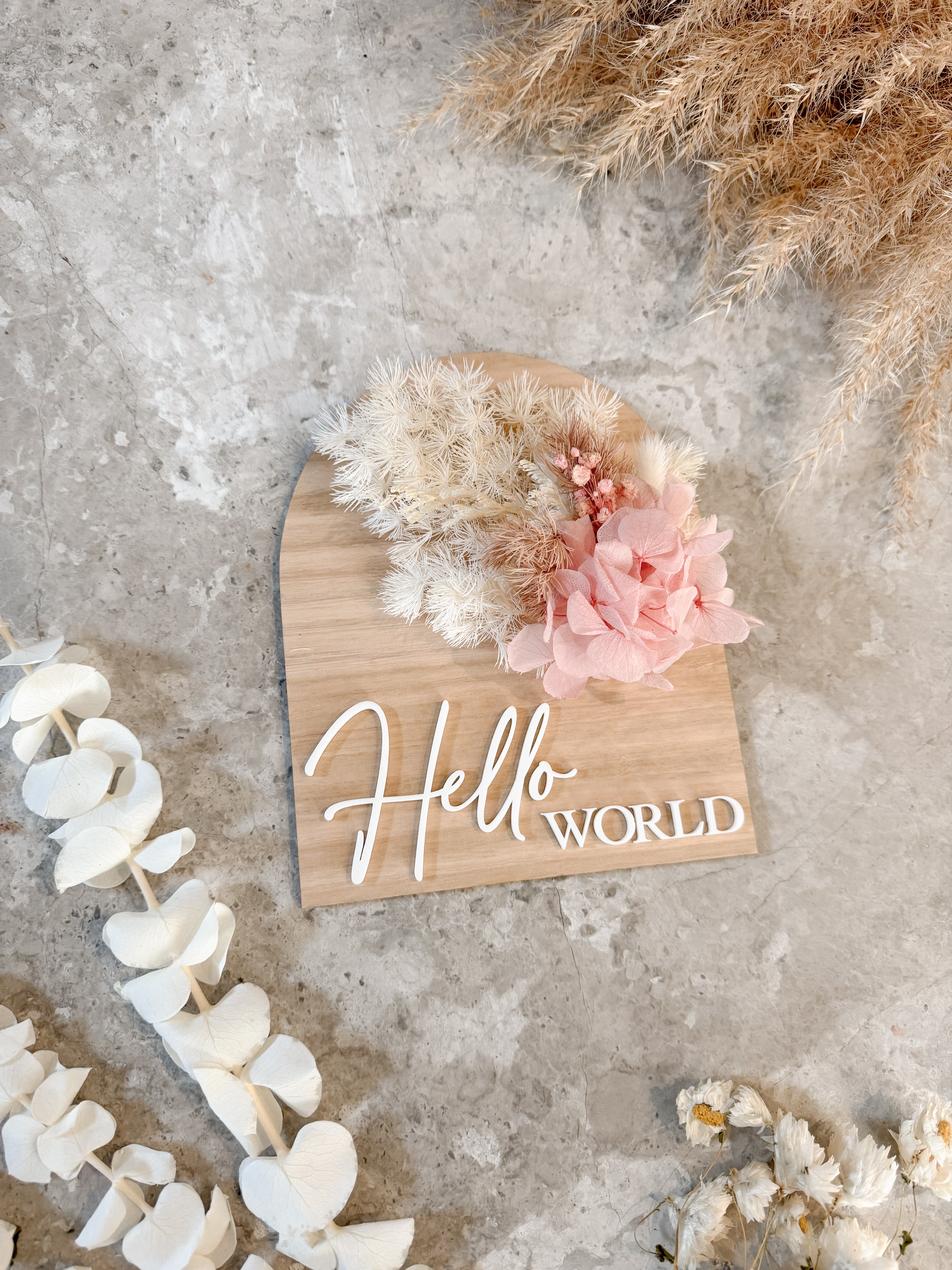 Dried floral wooden plaque with acrylic and/or laser engraved text or name, either arch or round shape, with dried preserved flowers tied to the plaque. Perfect for baby birth announcements or personalised gifts or keepsakes.