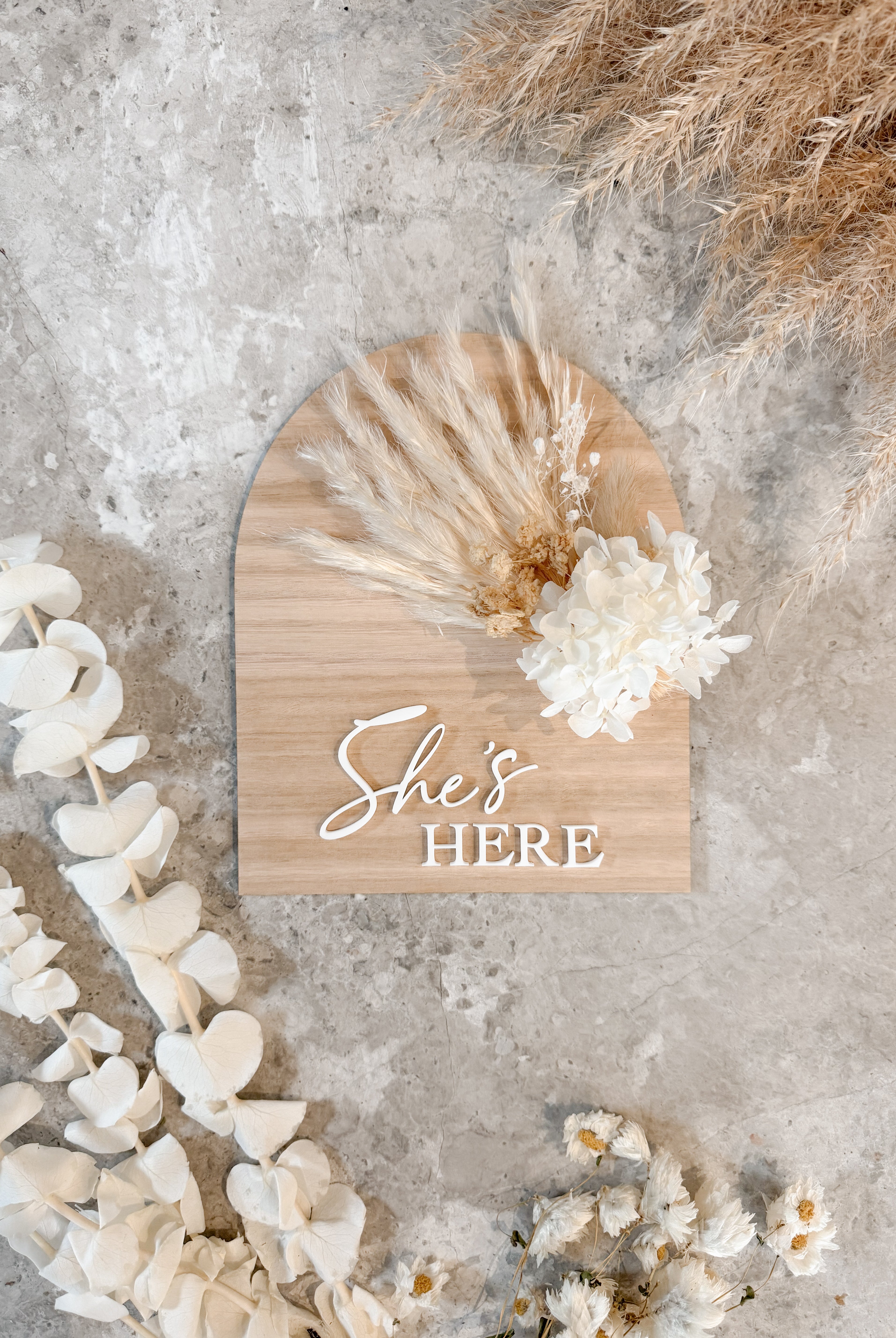 Dried floral wooden plaque with acrylic and/or laser engraved text or name, either arch or round shape, with dried preserved flowers tied to the plaque. Perfect for baby birth announcements or personalised gifts or keepsakes.