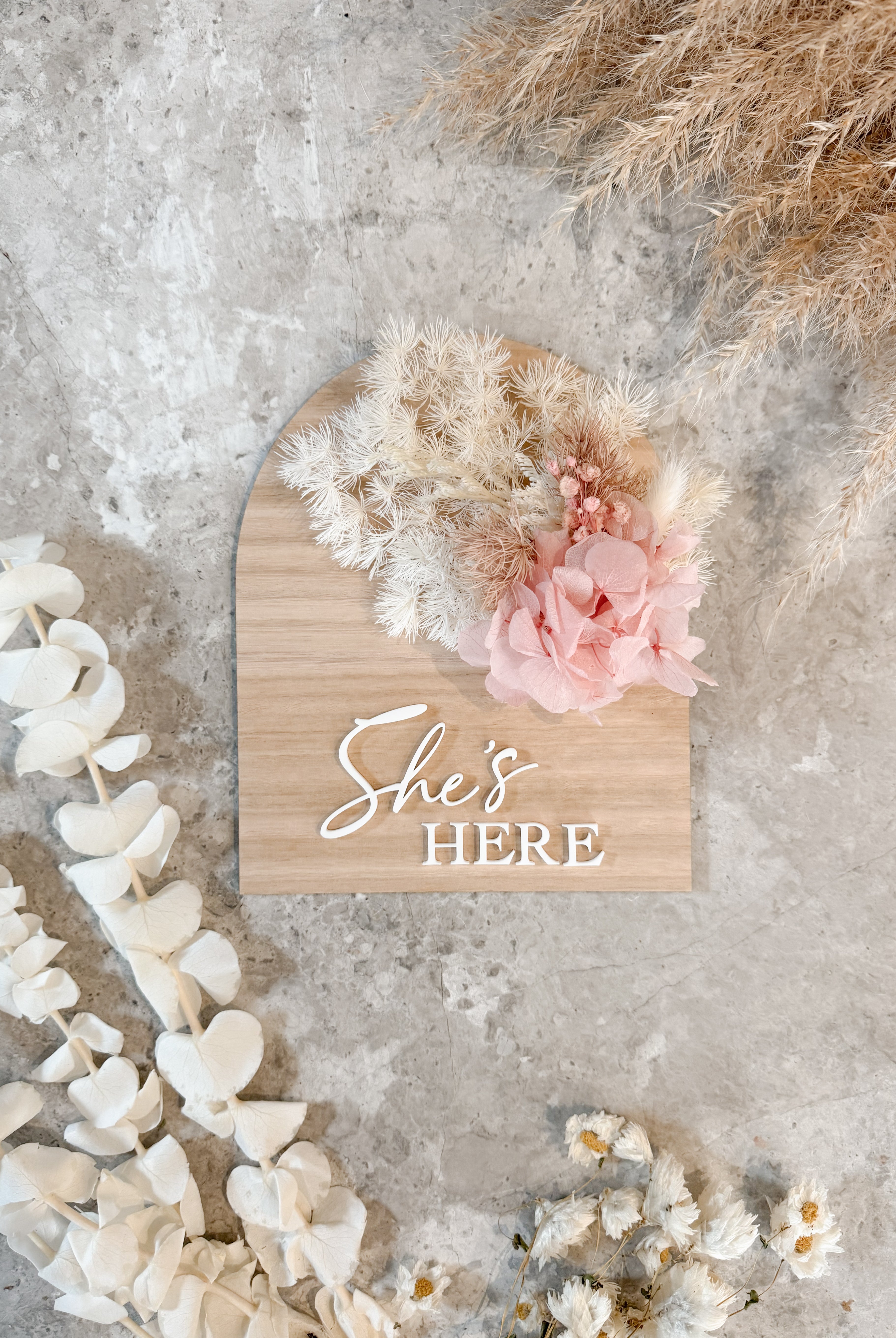 Dried floral wooden plaque with acrylic and/or laser engraved text or name, either arch or round shape, with dried preserved flowers tied to the plaque. Perfect for baby birth announcements or personalised gifts or keepsakes.