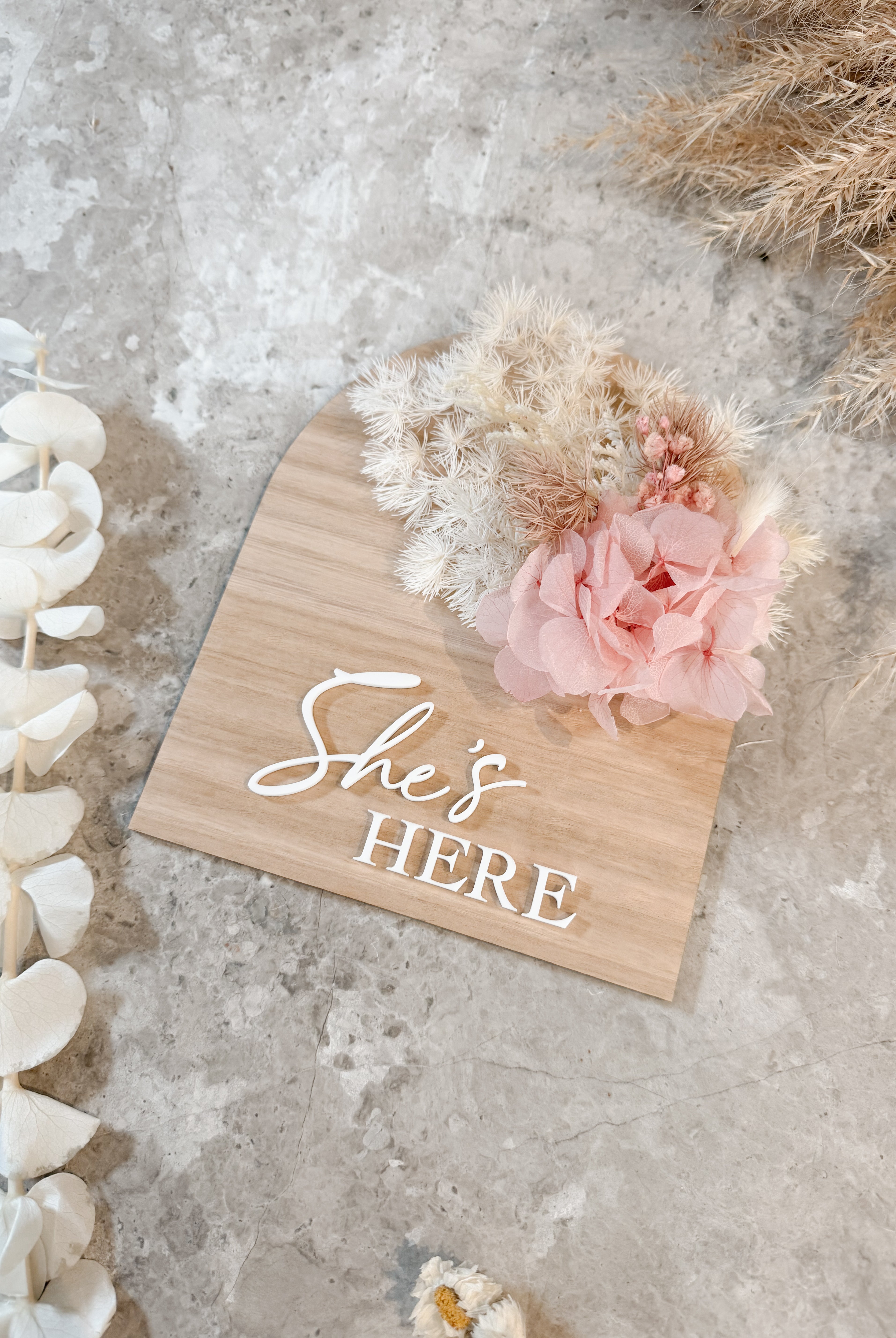 Dried floral wooden plaque with acrylic and/or laser engraved text or name, either arch or round shape, with dried preserved flowers tied to the plaque. Perfect for baby birth announcements or personalised gifts or keepsakes.