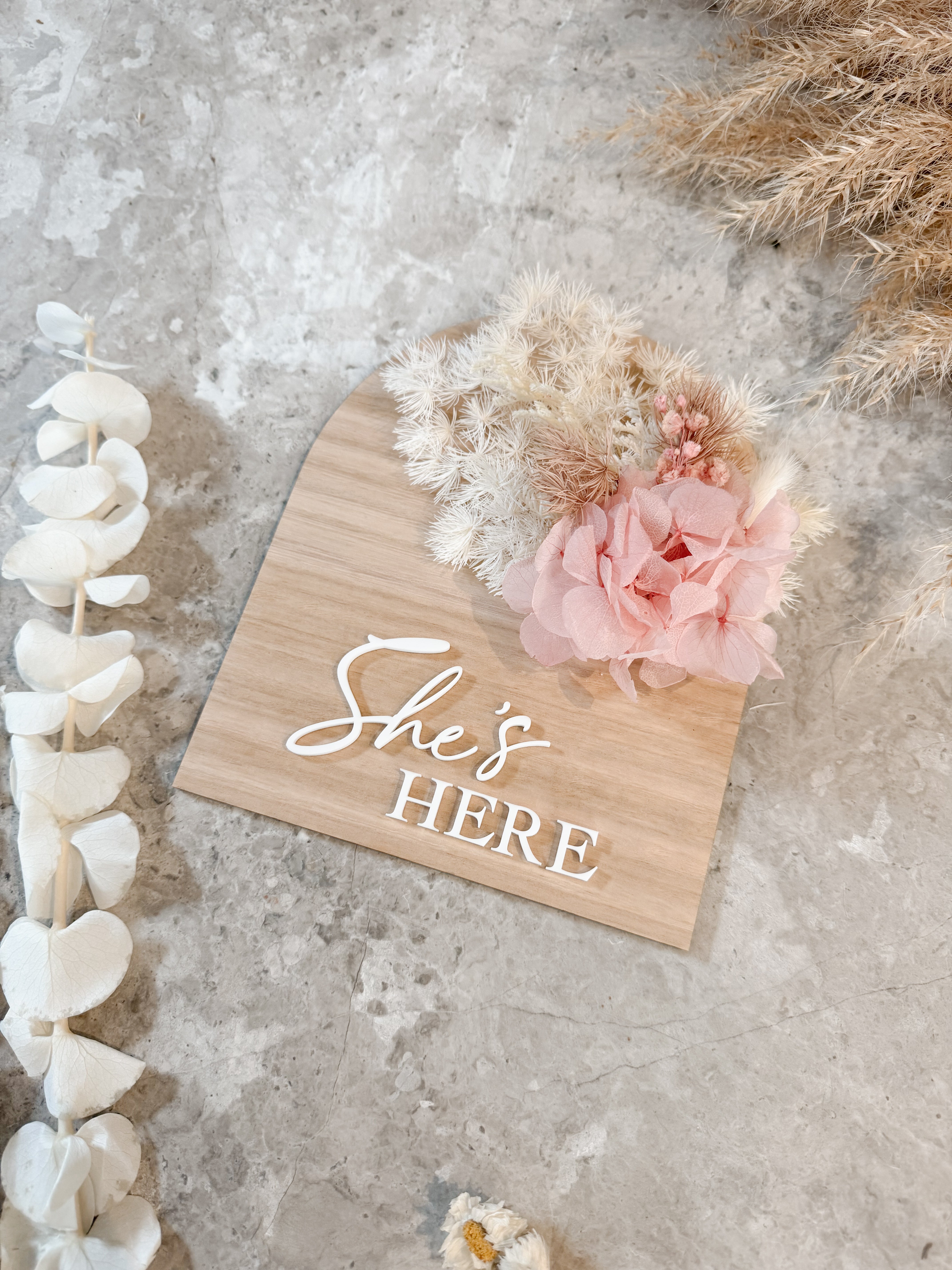 Dried floral wooden plaque with acrylic and/or laser engraved text or name, either arch or round shape, with dried preserved flowers tied to the plaque. Perfect for baby birth announcements or personalised gifts or keepsakes.