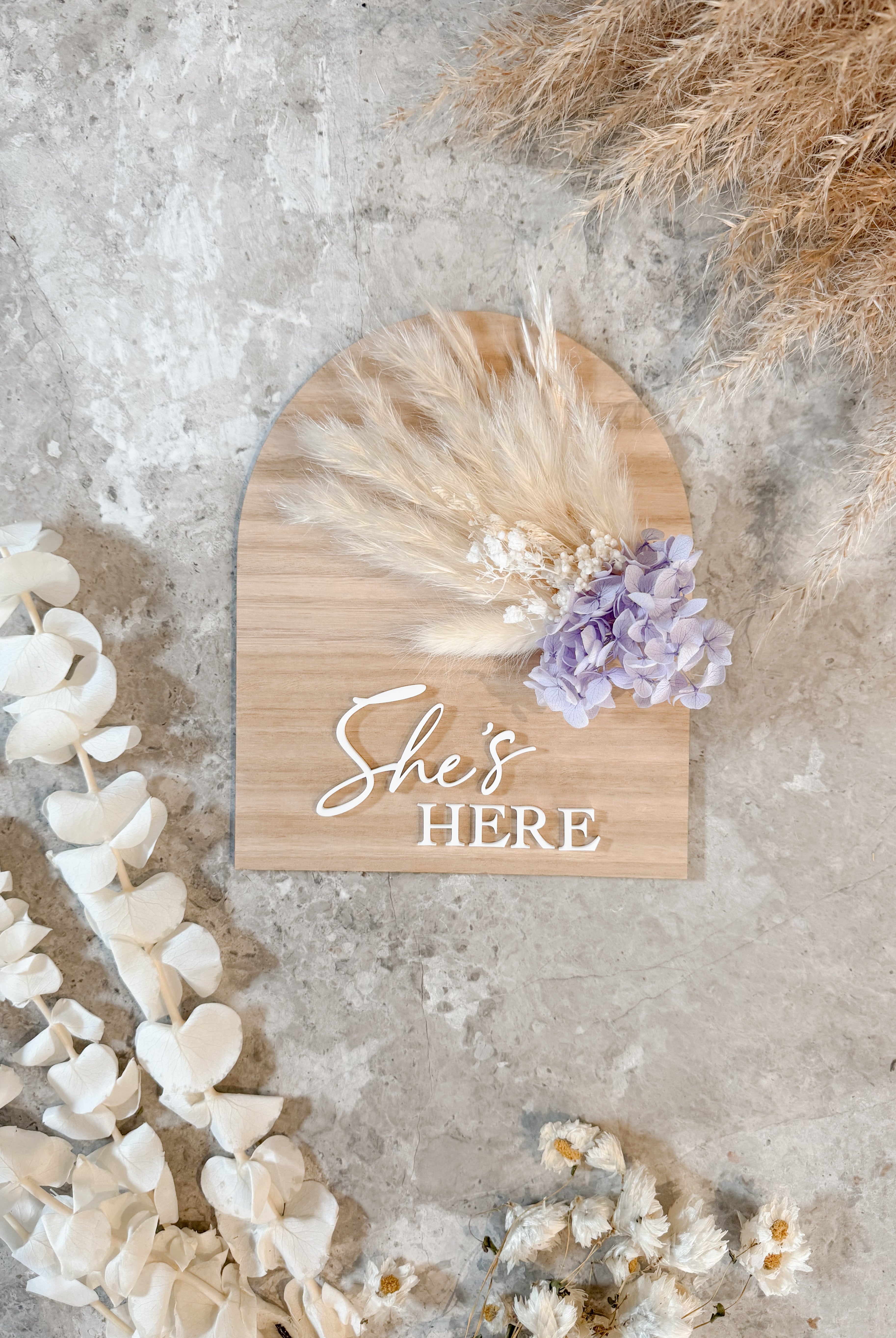 Dried floral wooden plaque with acrylic and/or laser engraved text or name, either arch or round shape, with dried preserved flowers tied to the plaque. Perfect for baby birth announcements or personalised gifts or keepsakes.