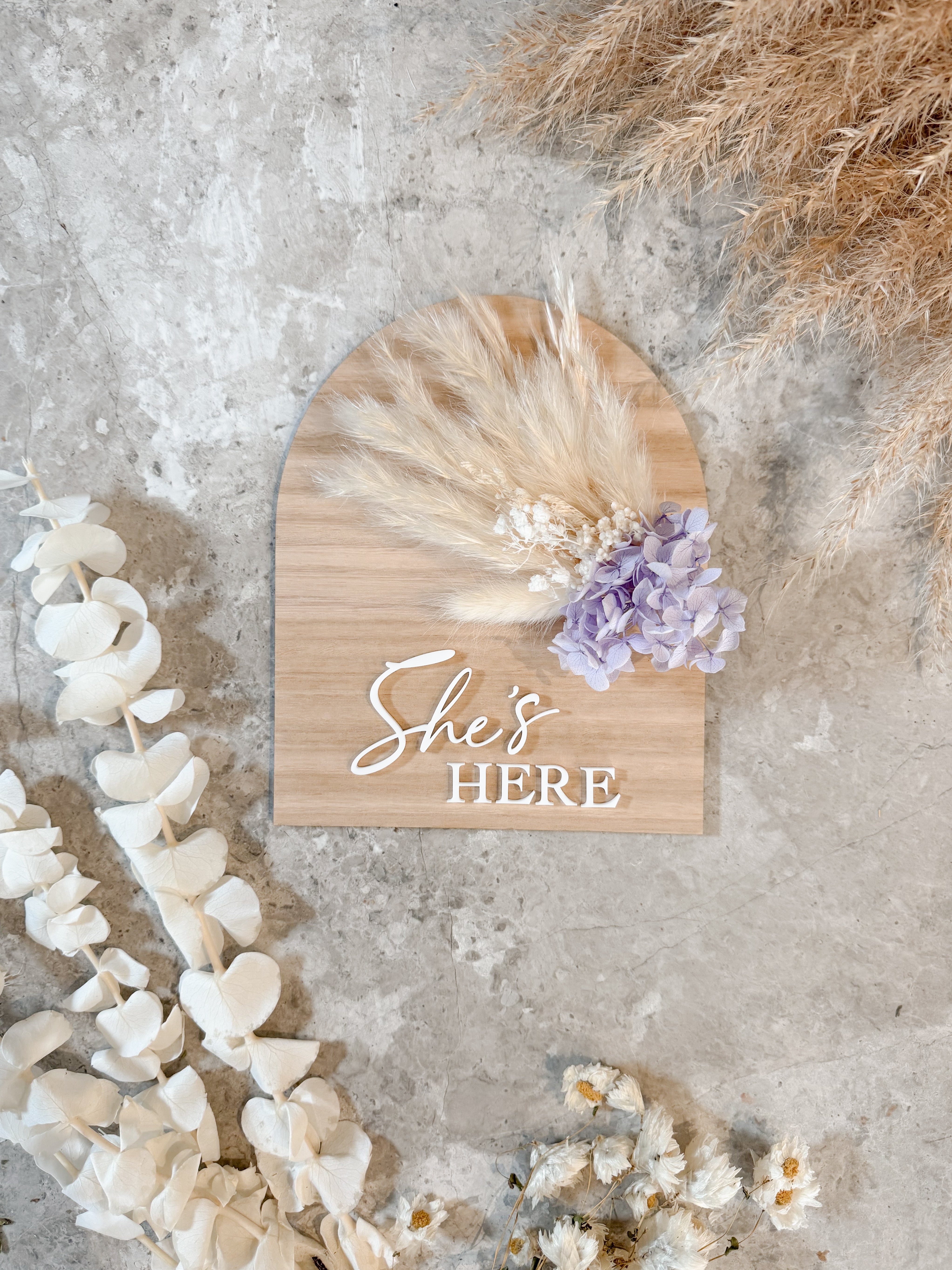 Dried floral wooden plaque with acrylic and/or laser engraved text or name, either arch or round shape, with dried preserved flowers tied to the plaque. Perfect for baby birth announcements or personalised gifts or keepsakes.