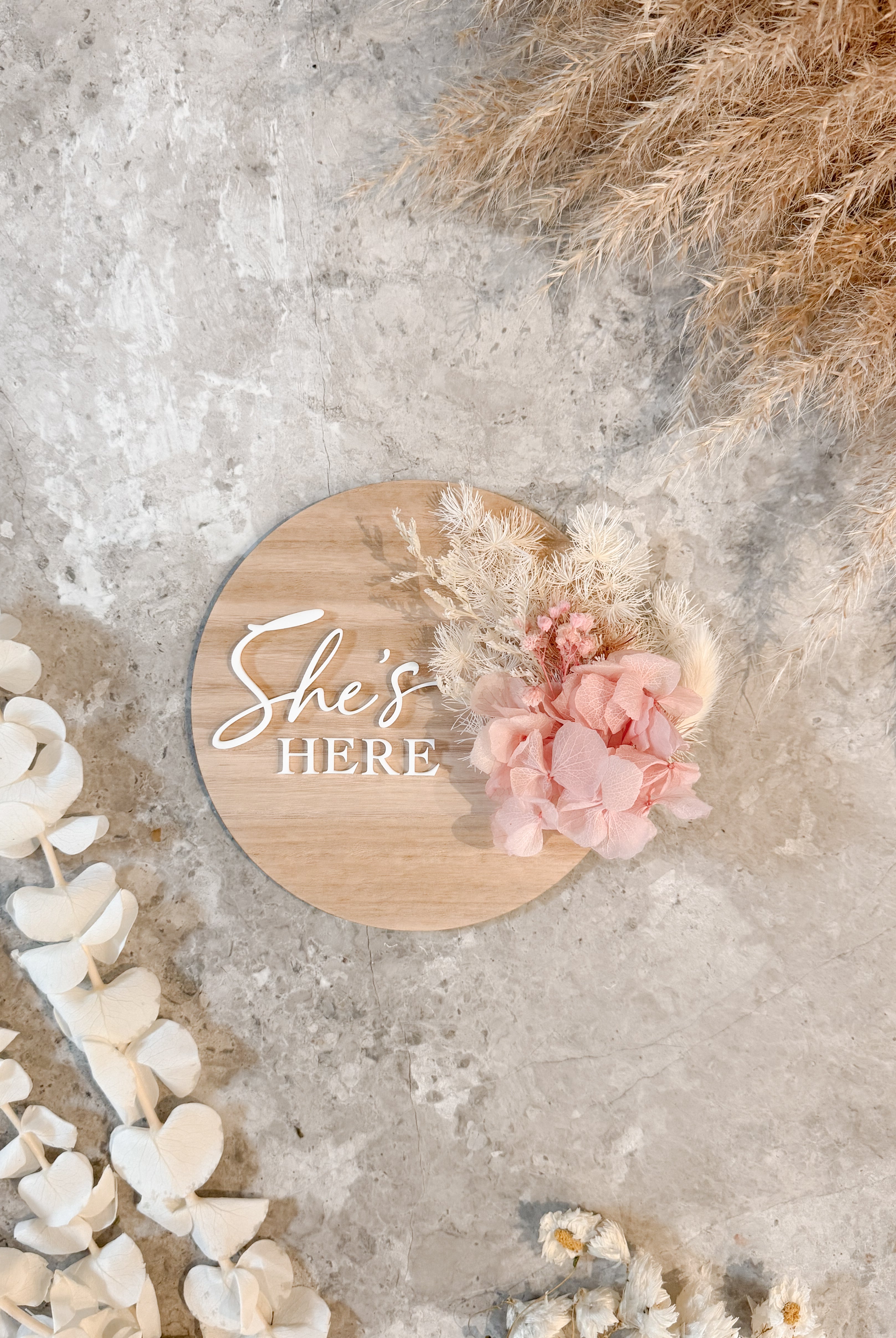Dried floral wooden plaque with acrylic and/or laser engraved text or name, either arch or round shape, with dried preserved flowers tied to the plaque. Perfect for baby birth announcements or personalised gifts or keepsakes.