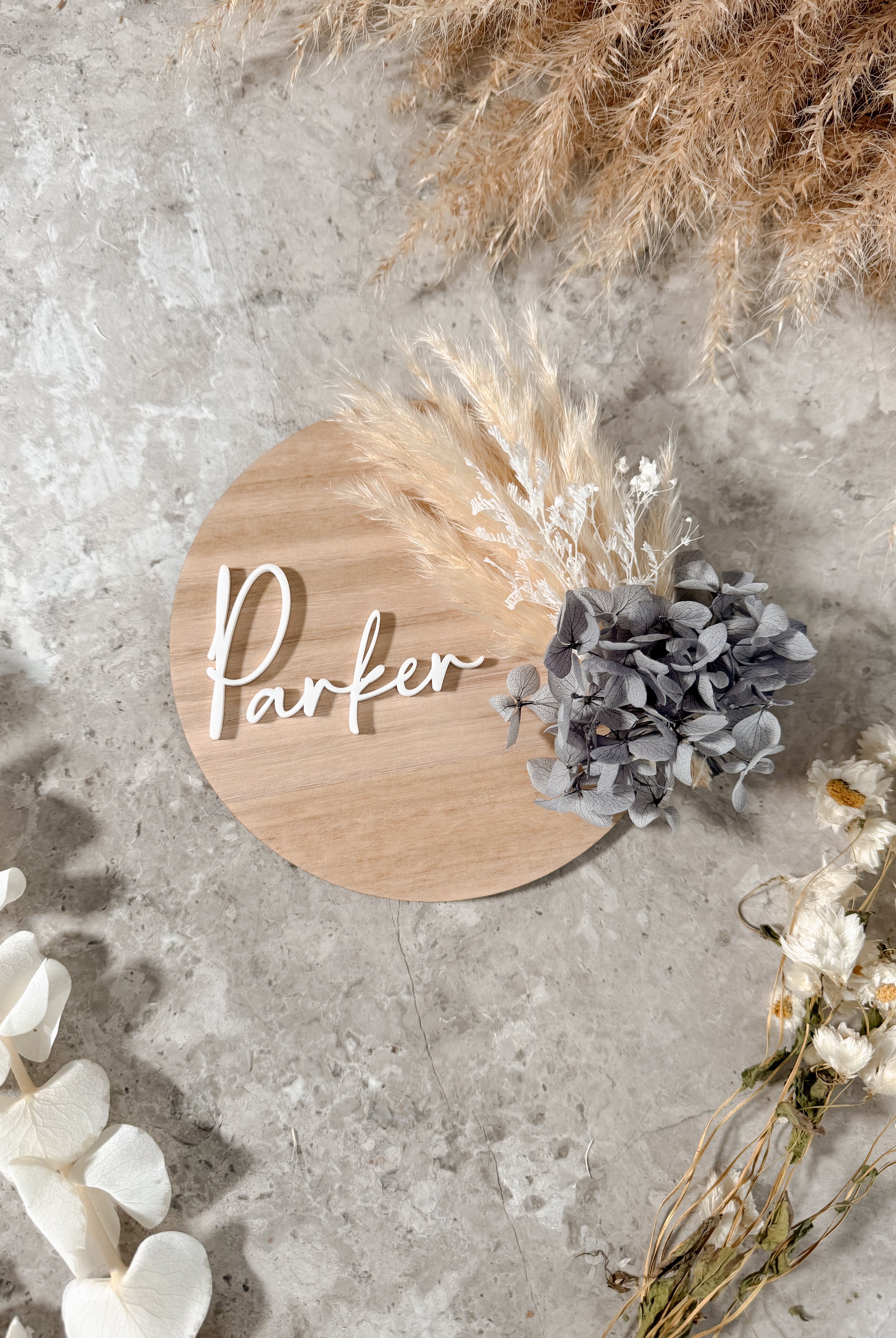 Dried floral wooden plaque with acrylic and/or laser engraved text or name, either arch or round shape, with dried preserved flowers tied to the plaque. Perfect for baby birth announcements or personalised gifts or keepsakes.