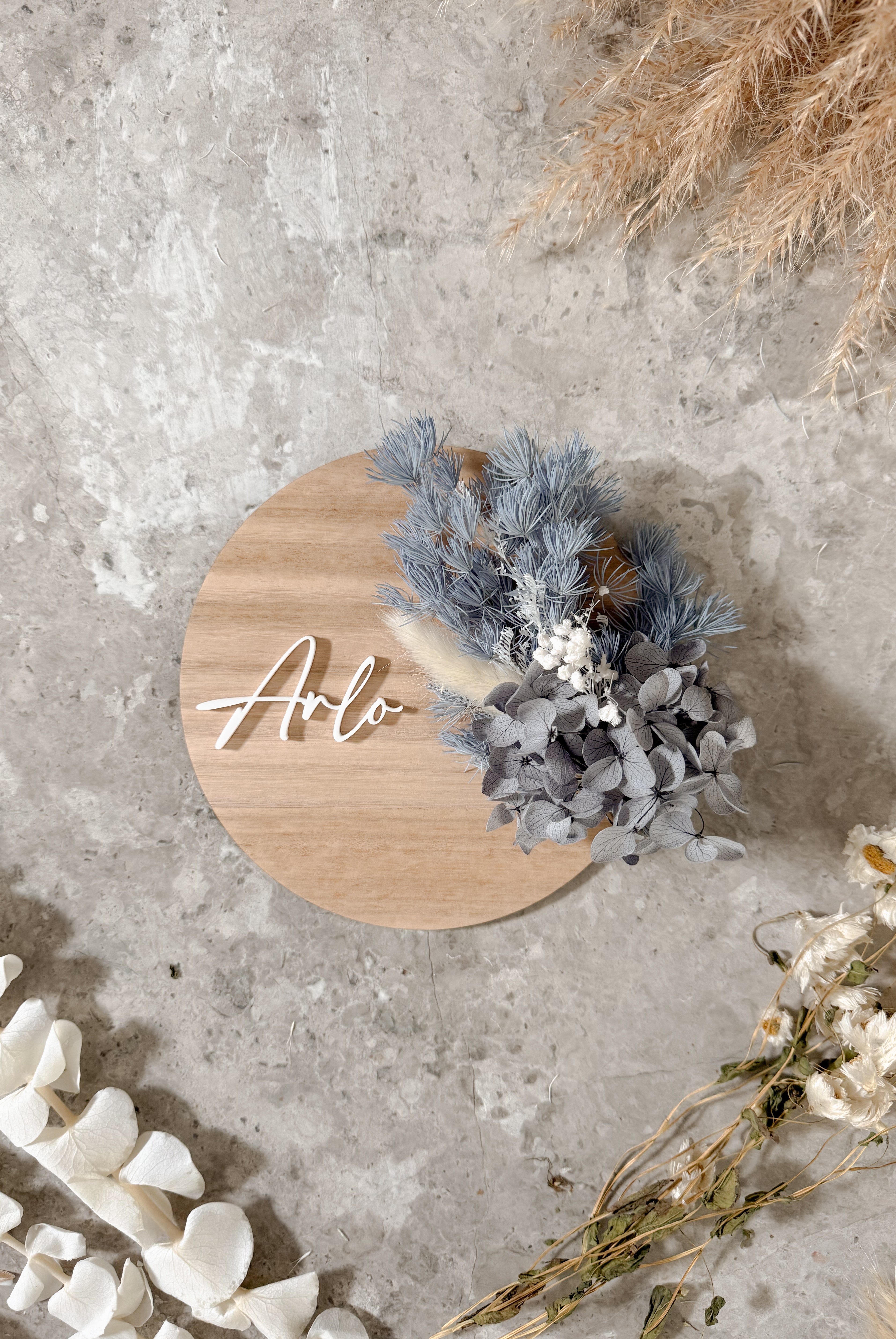 Dried floral wooden plaque with acrylic and/or laser engraved text or name, either arch or round shape, with dried preserved flowers tied to the plaque. Perfect for baby birth announcements or personalised gifts or keepsakes.