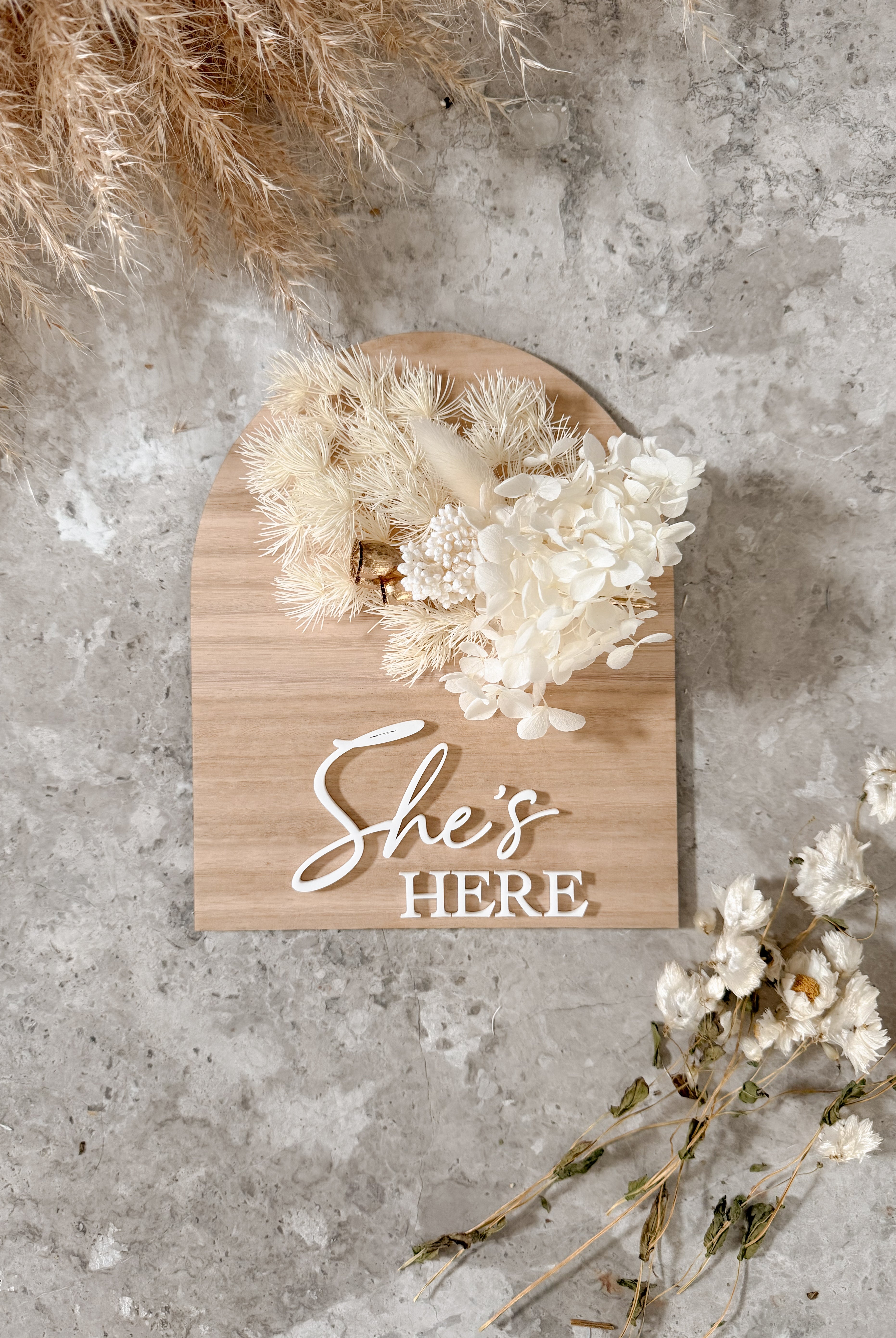 Dried floral wooden plaque with acrylic and/or laser engraved text or name, either arch or round shape, with dried preserved flowers tied to the plaque. Perfect for baby birth announcements or personalised gifts or keepsakes.