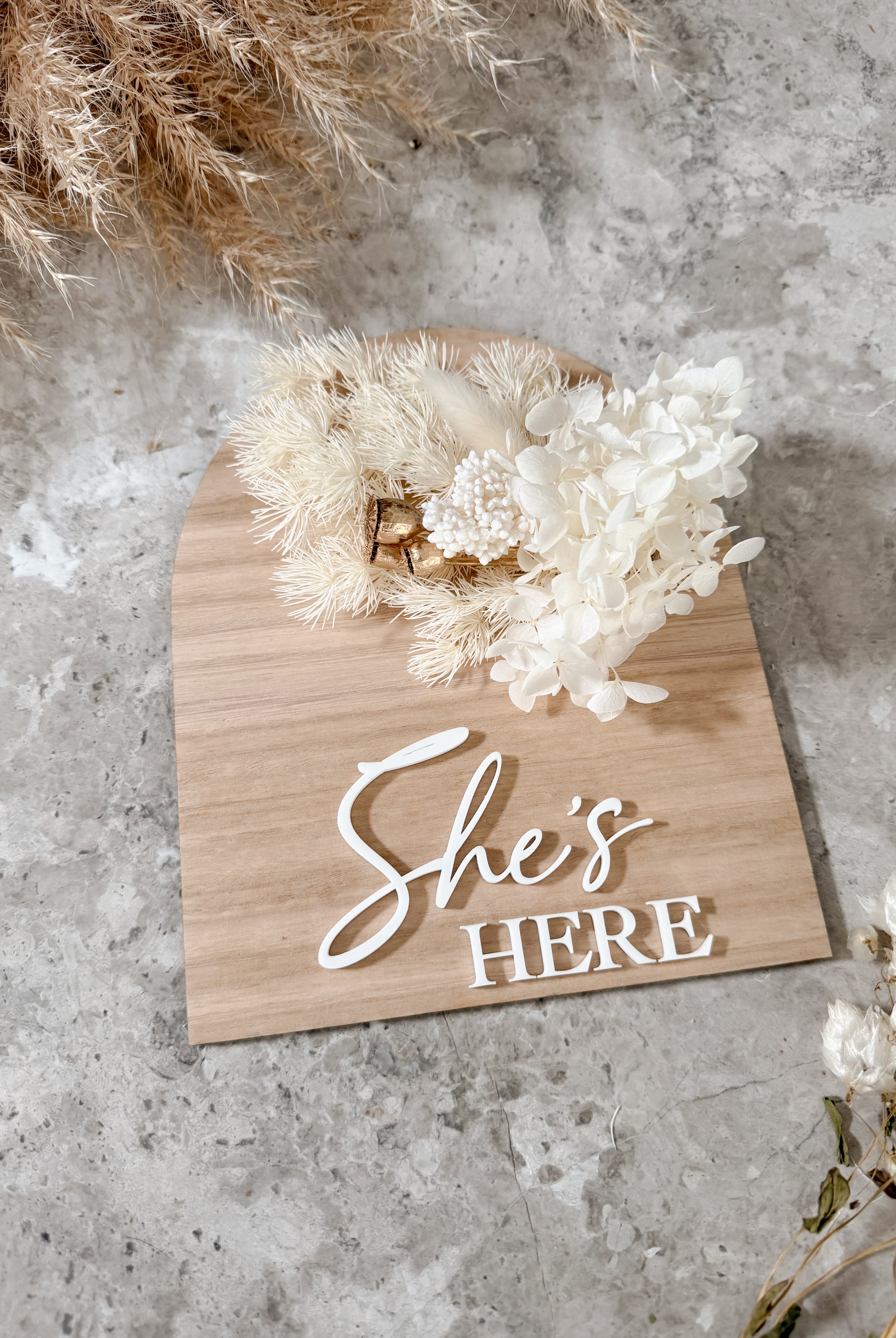 Dried floral wooden plaque with acrylic and/or laser engraved text or name, either arch or round shape, with dried preserved flowers tied to the plaque. Perfect for baby birth announcements or personalised gifts or keepsakes.