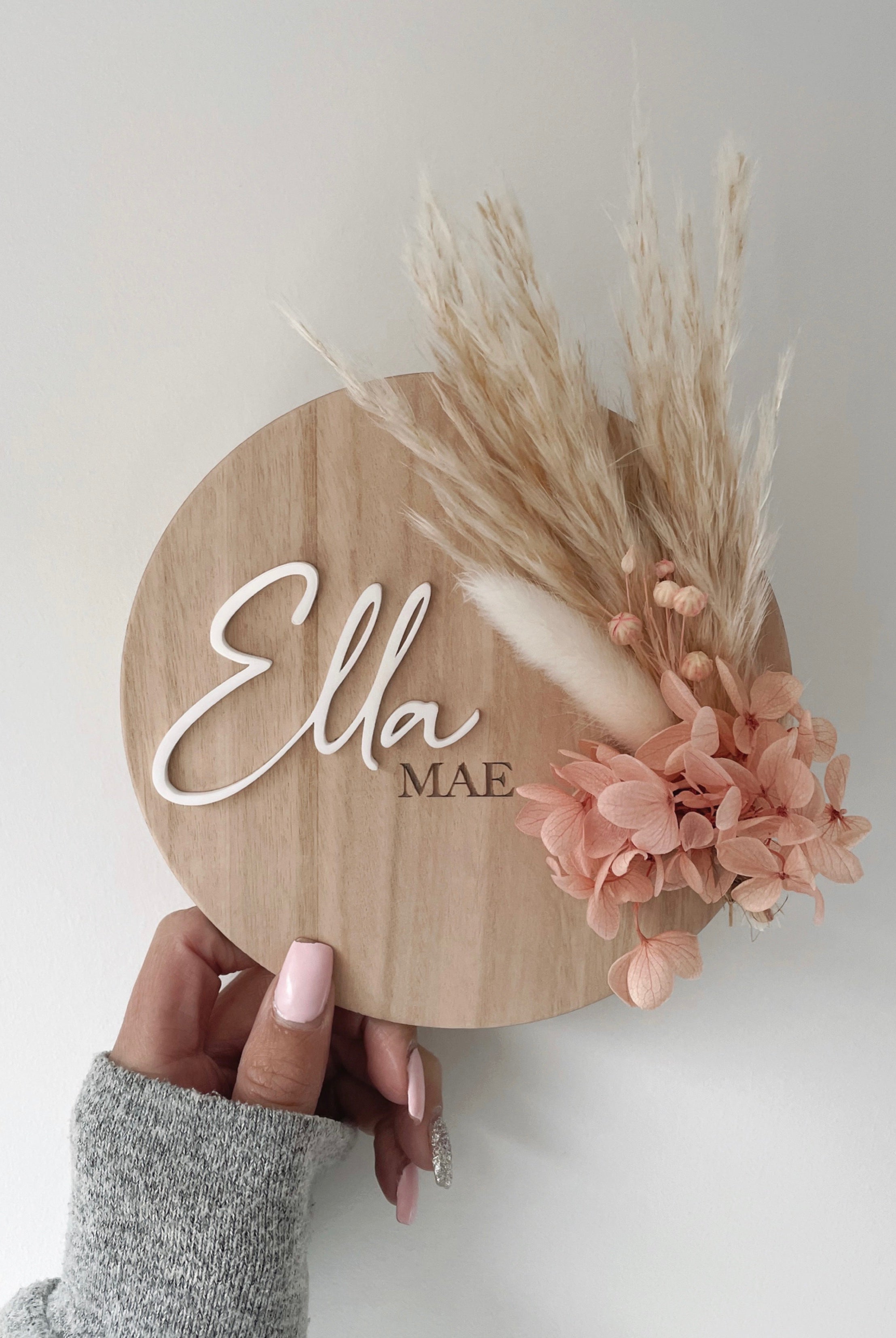 Dried floral wooden plaque with acrylic and/or laser engraved text or name, either arch or round shape, with dried preserved flowers tied to the plaque. Perfect for baby birth announcements or personalised gifts or keepsakes.