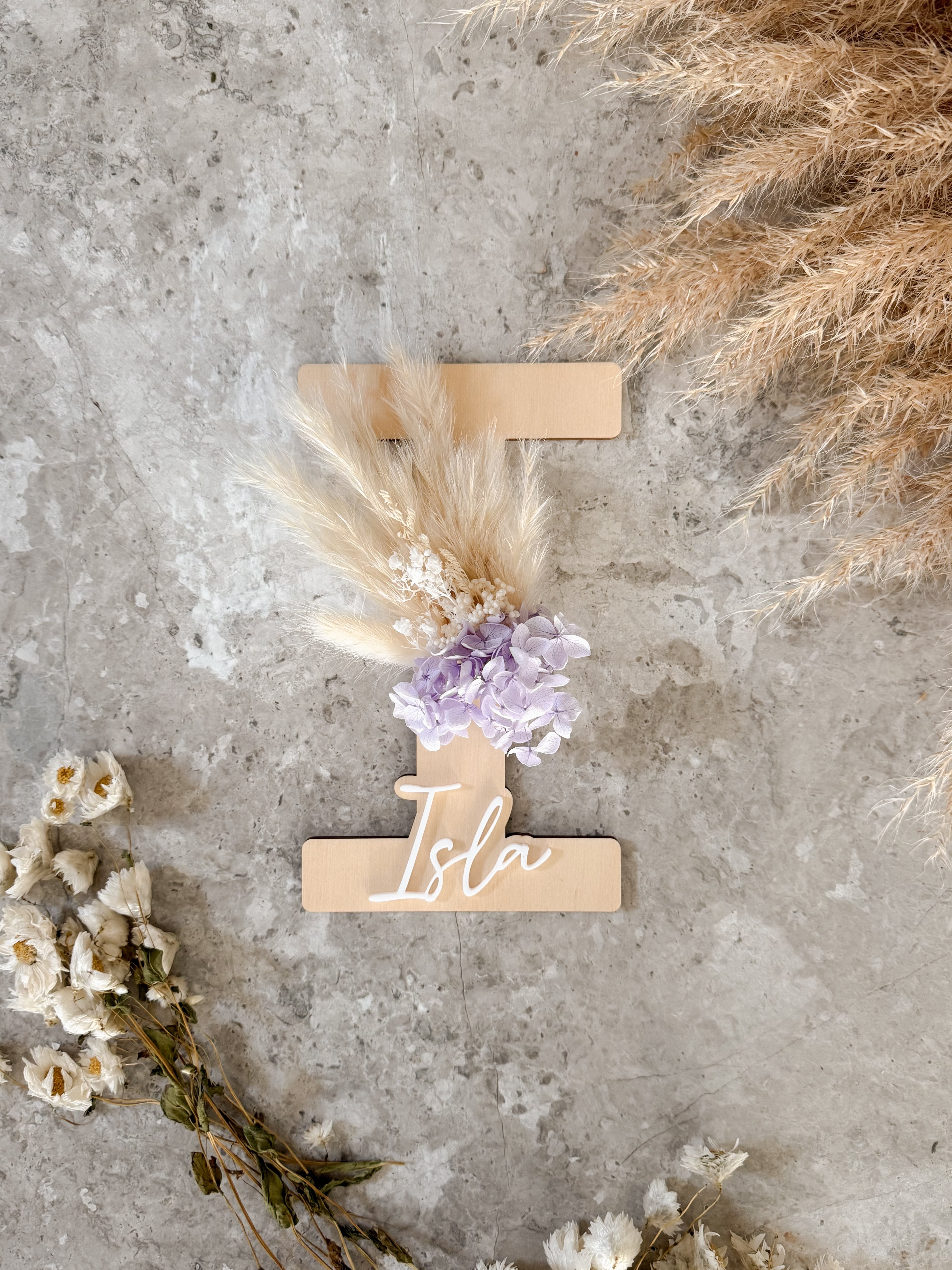 Dried floral wooden plaque with acrylic and/or laser engraved text or name, letter/initial, with dried preserved flowers tied to the plaque. Perfect for baby birth announcements or personalised gifts or keepsakes.
