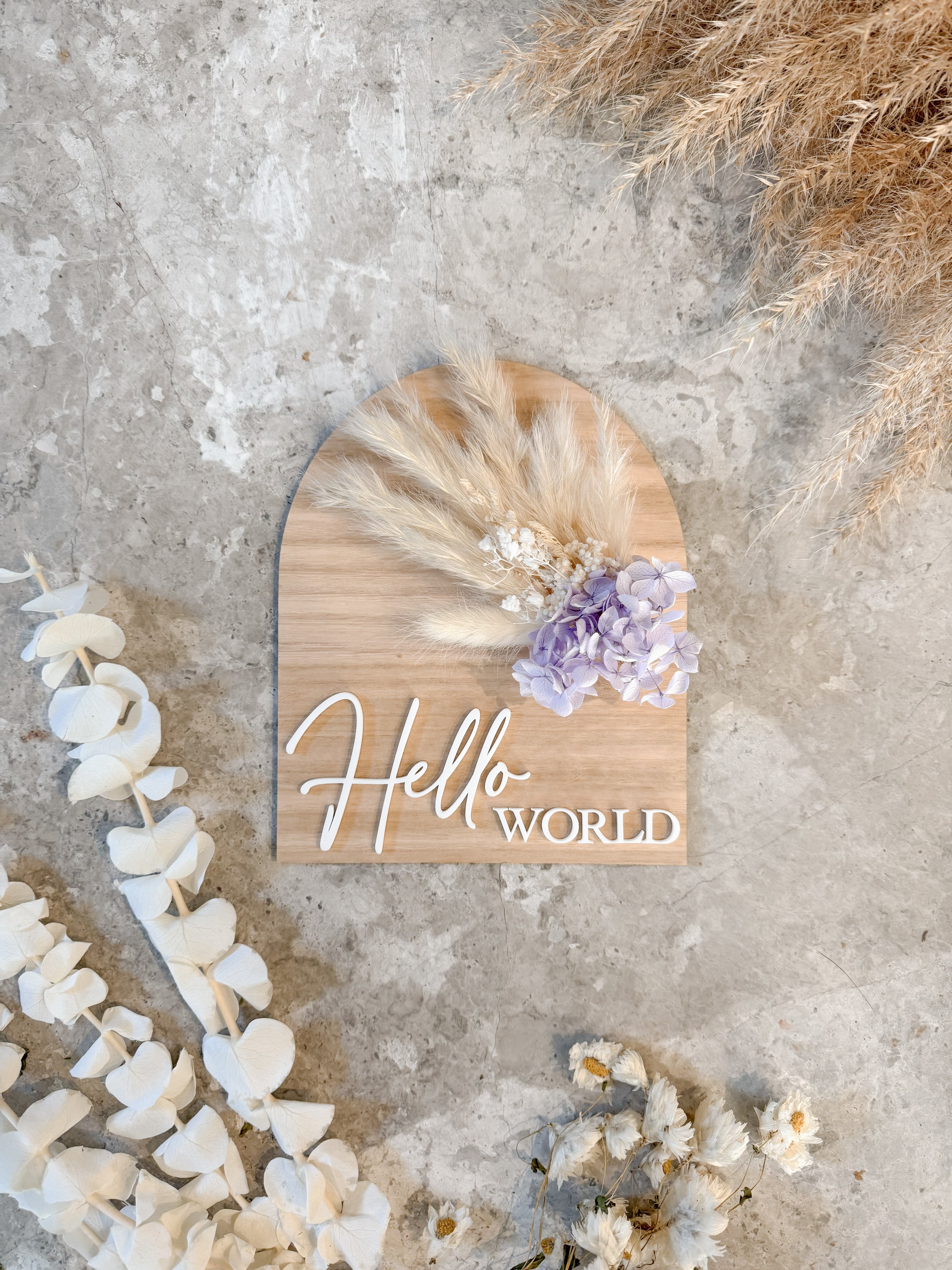 Dried floral wooden plaque with acrylic and/or laser engraved text or name, either arch or round shape, with dried preserved flowers tied to the plaque. Perfect for baby birth announcements or personalised gifts or keepsakes.