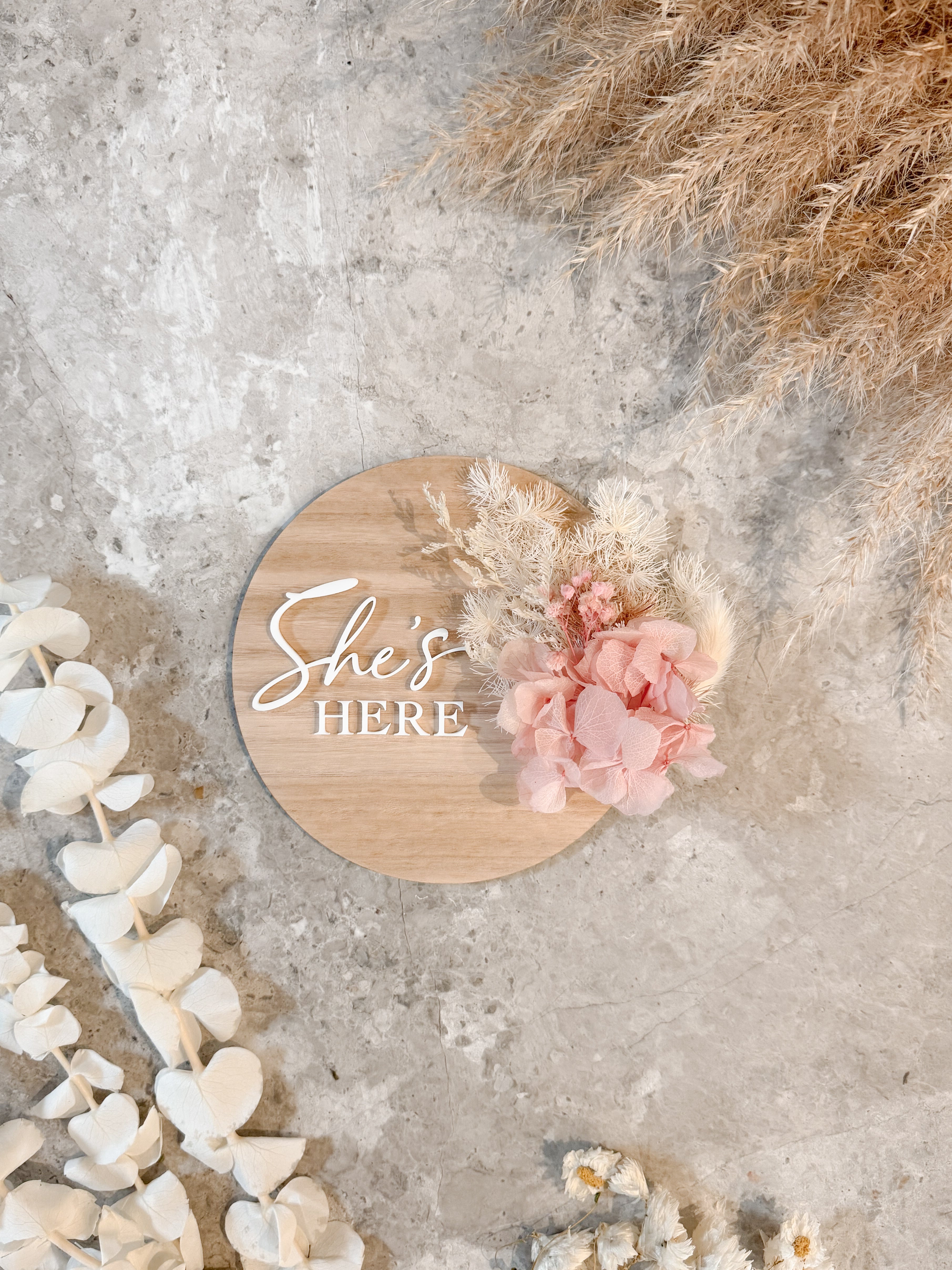 Dried floral wooden plaque with acrylic and/or laser engraved text or name, either arch or round shape, with dried preserved flowers tied to the plaque. Perfect for baby birth announcements or personalised gifts or keepsakes.